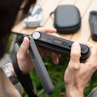 holding a black silicon protective cover for the PocketCloud portable NAS in outdoor background